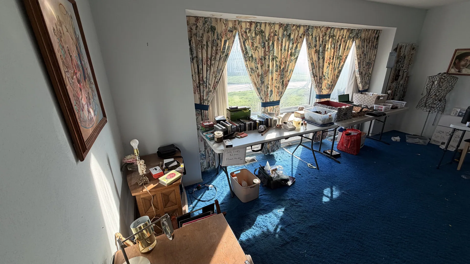 Living room blue carpet folding tables dvds at an estate sale O'Fallon