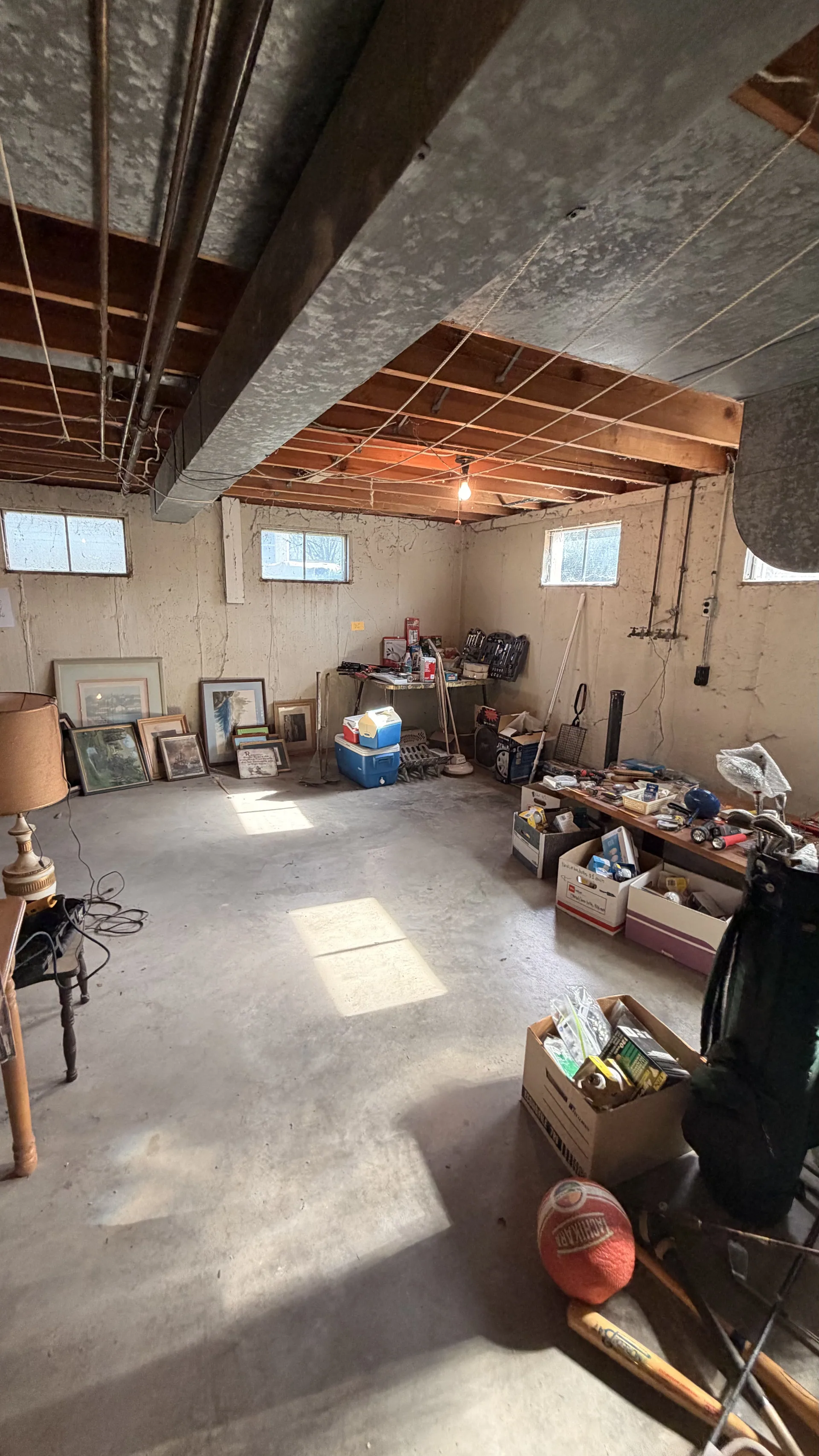Gallery/unfinished basement framed art golf bag tools at an estate sale of